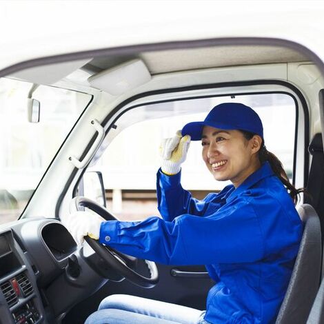 トラックで出発する女性スタッフ